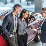 Mujer mira detalles para elegir coche de alquiler perfecto